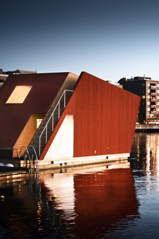 Badstua Albatrossen er formet som et avlangt trapes, ligger i Bjørvika og er kledd i røde paneler på utsida.